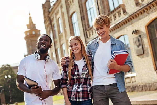 Grupo de amigos positivos disfrutando de un paseo por el campus — Foto de Stock