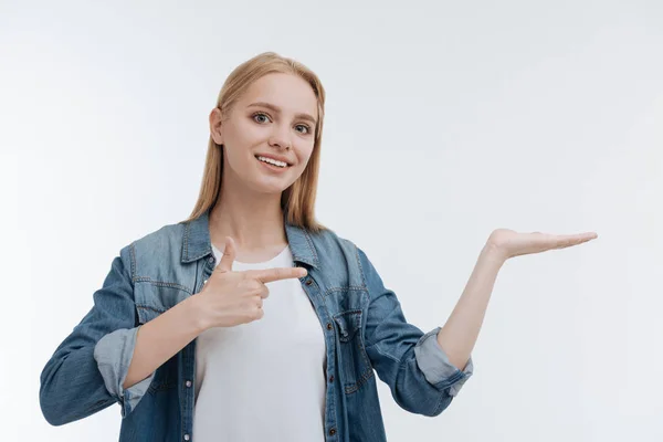 Fermecătoare tânără femeie arătând spre palma stângă — Fotografie, imagine de stoc