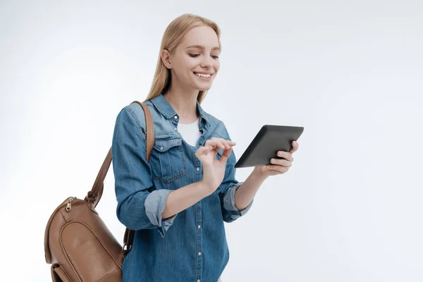 Aantrekkelijke lachende vrouw haar tablet kijken — Stockfoto