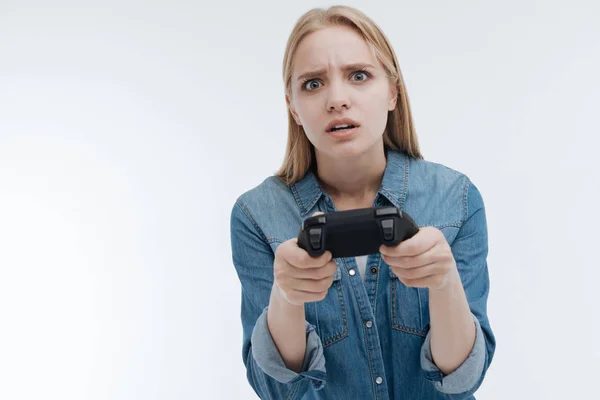 Confundida chica sosteniendo la consola de juego en ambas manos — Foto de Stock