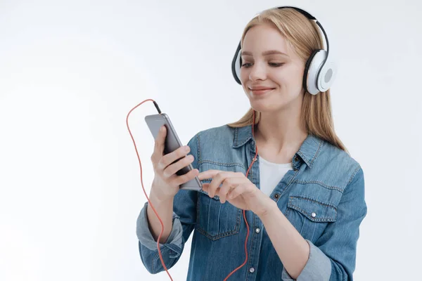 Delighted student choosing necessary song — Stock Photo, Image
