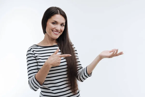 Nice looking longhaired woman pointing at her left hand — Stock Photo, Image