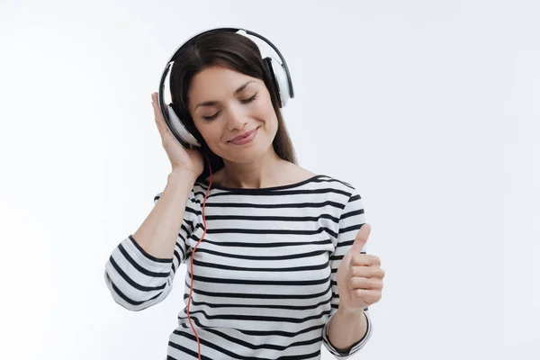 Enigmática jovem mulher sendo satisfeito com fones de ouvido — Fotografia de Stock