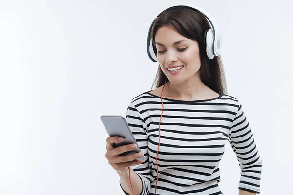 Bruna attraente guardando verso il basso il suo telefono — Foto Stock