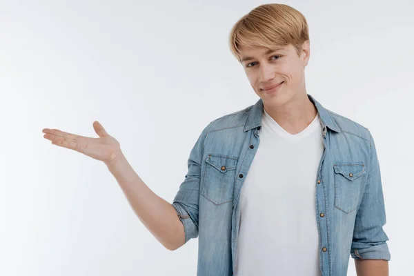 Positive male person putting hand as if demonstrating something — Stock Photo, Image