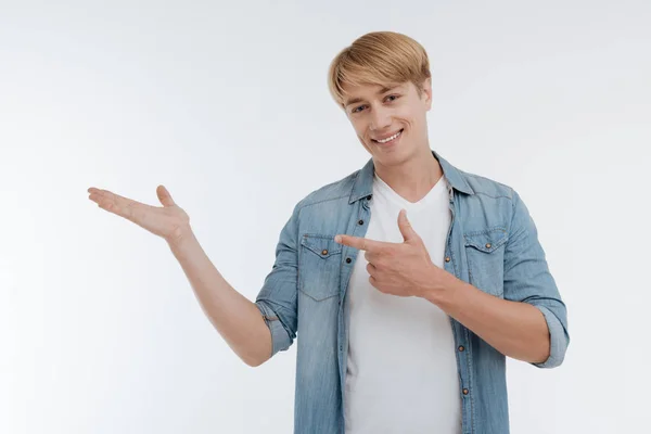 Atraente loira masculino apontando para sua mão direita — Fotografia de Stock