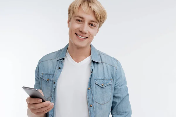 Bonito homem segurando seu telefone na mão esquerda — Fotografia de Stock