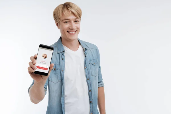 Usměvavý mladý muž prokazující jeho telefon — Stock fotografie