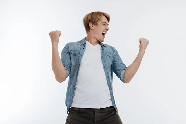 Satisfied young man raising his fists — Stock Photo, Image