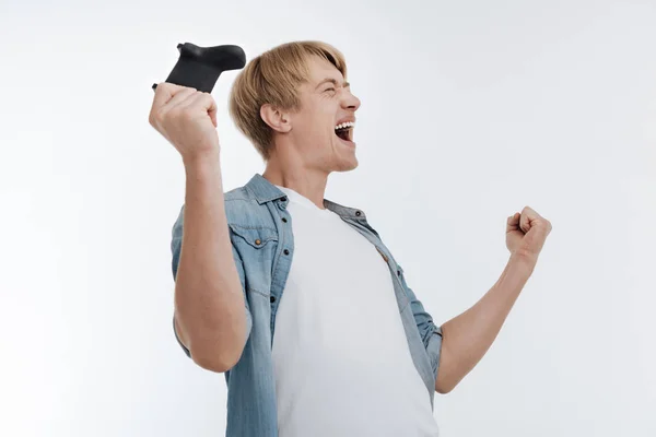 Homem satisfeito comemorando sua vitória no jogo — Fotografia de Stock