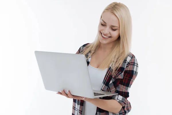 Ganska leende flicka tittar på hennes laptop — Stockfoto