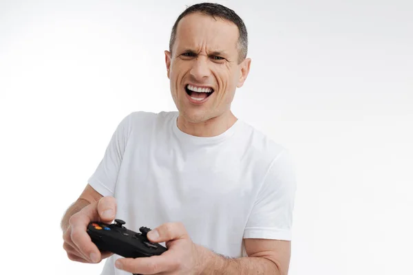 Emotional man playing with game console — Stock Photo, Image