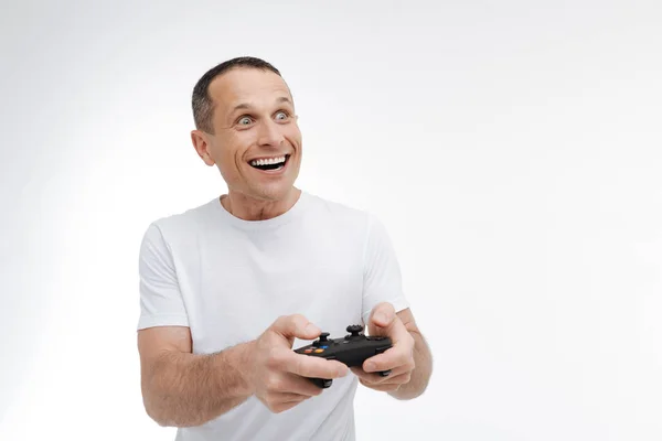 Pessoa masculina apaixonada jogando com console de jogo — Fotografia de Stock