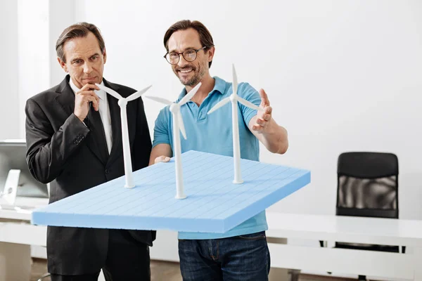 Příjemné inženýr ukazuje model větrné elektrárny s šéfem — Stock fotografie
