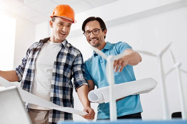 Jovem construtor e arquiteto olhando para os modelos de turbinas eólicas — Fotografia de Stock