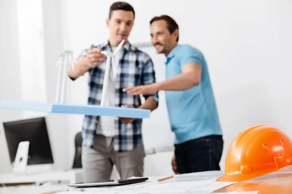 Colleagues discussing the height of wind turbine models — Stock Photo, Image