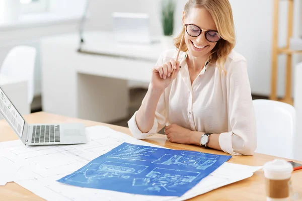 Delightful architect exploring engineering scheme in the office — Stock Photo, Image