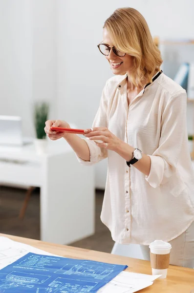 Diseñador contento utilizando un dispositivo moderno en la oficina —  Fotos de Stock