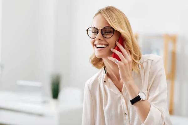 Задоволена жінка використовує смартфон в офісі — стокове фото