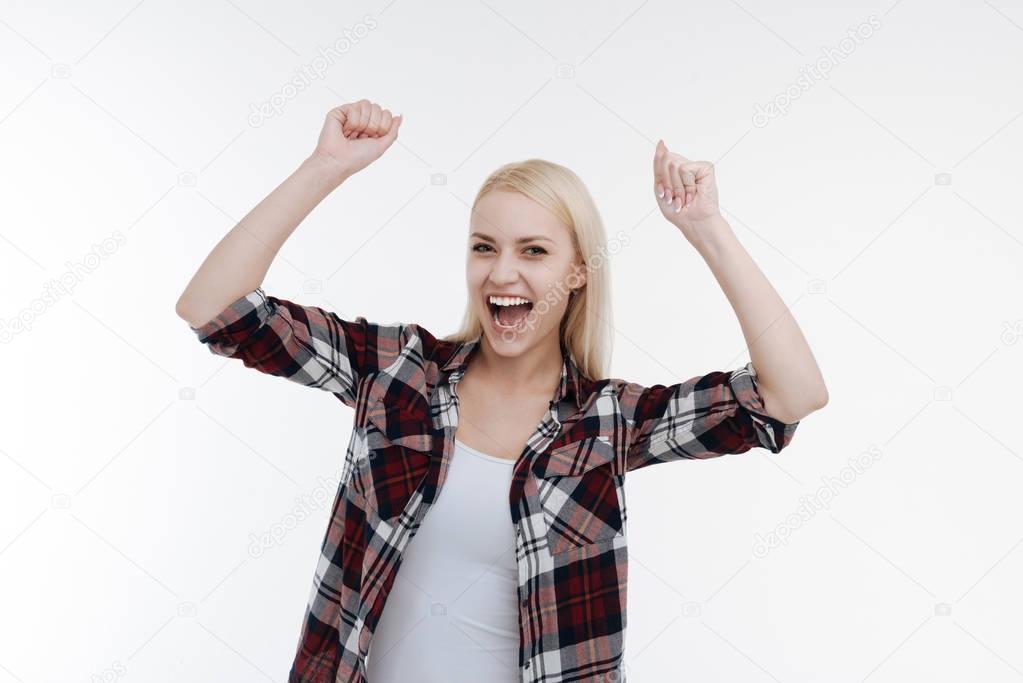 Pleased blonde raising her both arms up