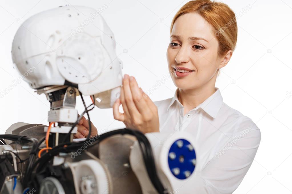 Gentle motivated woman touching robots face