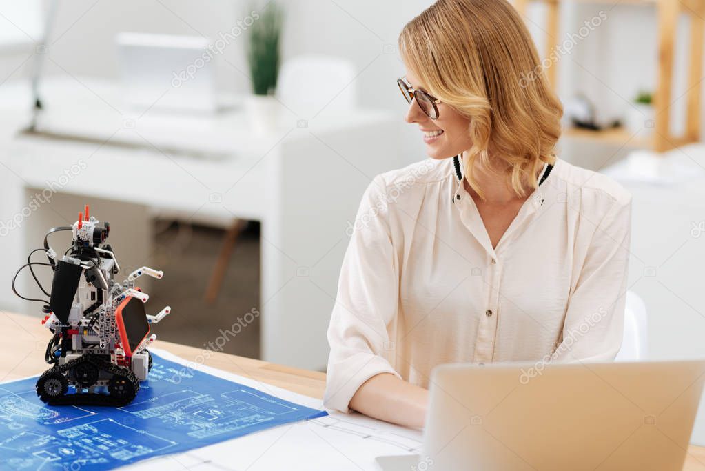 Interested woman working with robot in the office
