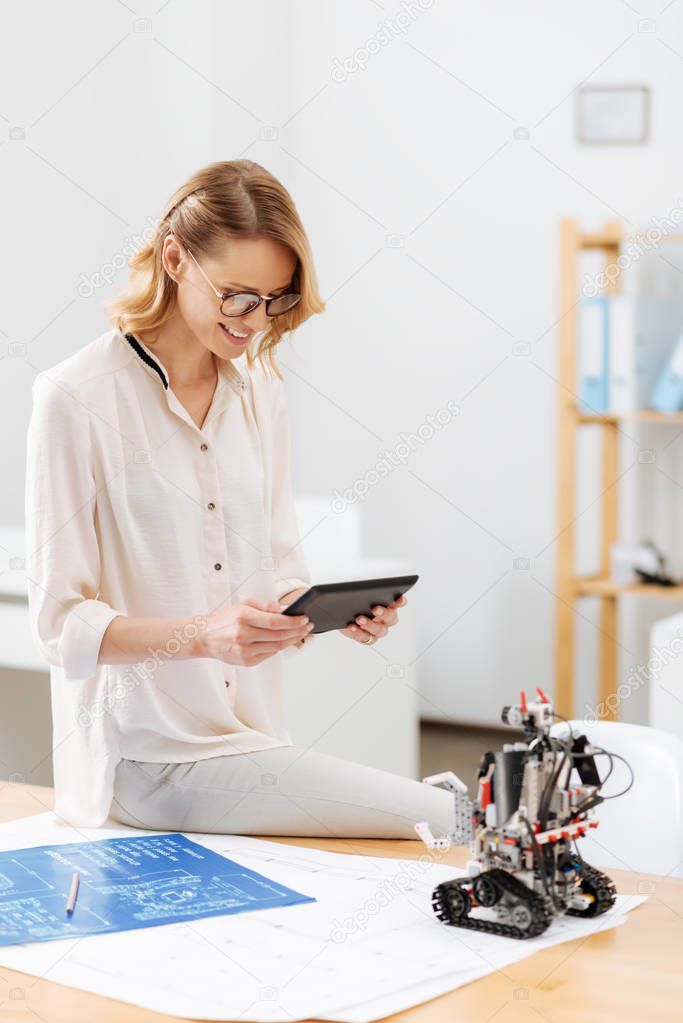Happy technology specialist working with robot in the laboratory