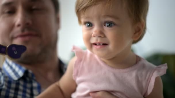 Позитивный взрослый мужчина играет со своей маленькой дочерью — стоковое видео