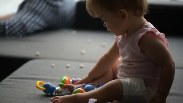 Söt liten knatte spelar på soffan — Stockvideo