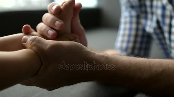 Close up of a caring father making a massage of a little baby — Stock Video