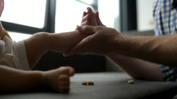 Любящий отец играет с малышом на диване — стоковое видео