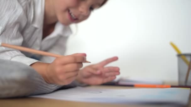 Schattig klein meisje tekenen aan de tafel — Stockvideo