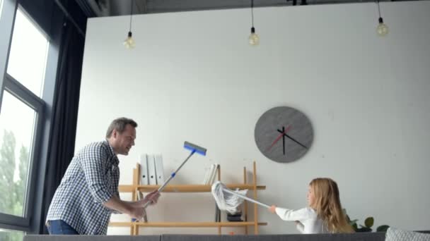 Schattig klein meisje en haar vader spelen tijdens het schoonmaken in de flat — Stockvideo