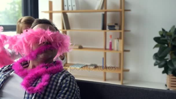 Милая красивая девушка надевает розовый шарф на своего отца — стоковое видео