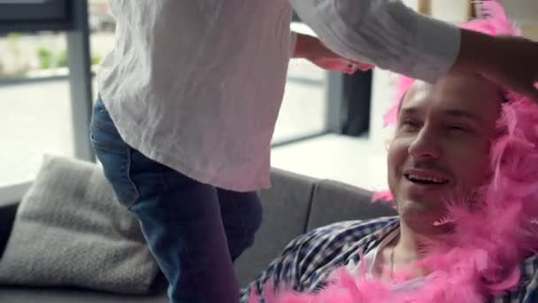 Радостная маленькая девочка в розовом шарфе на своем отце — стоковое видео