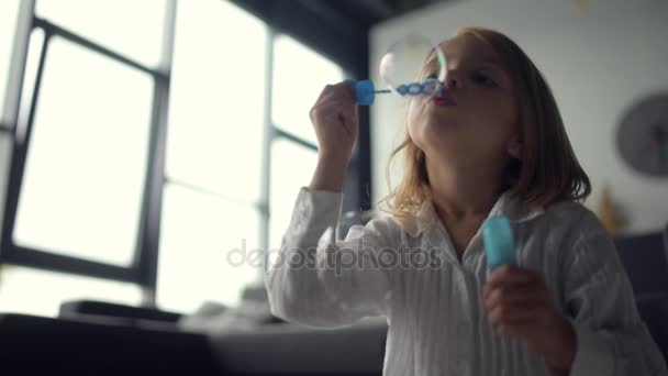 Vrolijke mooi meisje zeepbellen blazen — Stockvideo