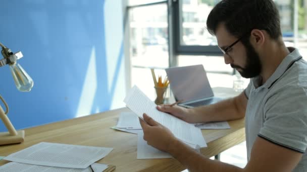 Estudiante masculino enfocado trabajando en tareas domésticas — Vídeos de Stock