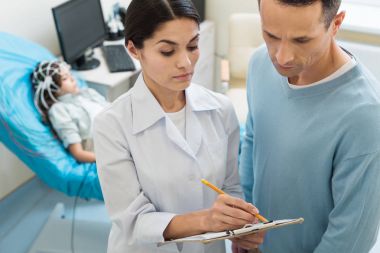 Kadın doktor onun imza koymak için üst soran
