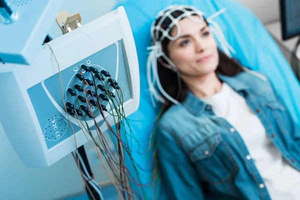 Крупный план электроэнцефалографа, регистрирующего мозговые волны женщины — стоковое фото