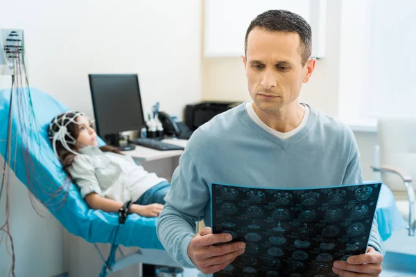 Pai examinando resultados tomográficos de sua filha — Fotografia de Stock