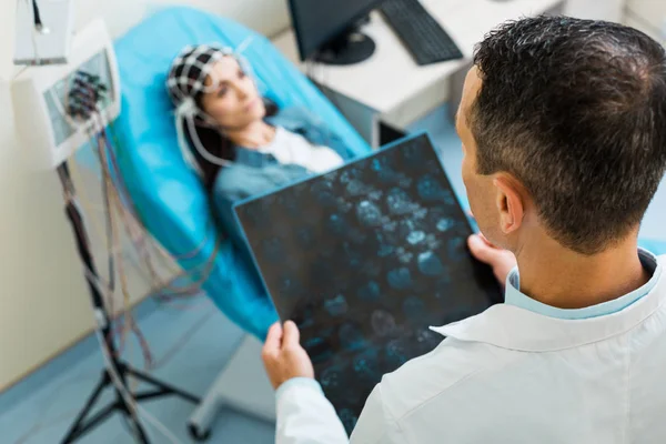 Vista dall'alto del medico che esamina i risultati CT della giovane donna — Foto Stock
