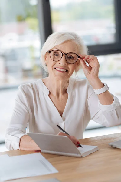 Glad smart kvinna fastställande hennes glasögon — Stockfoto