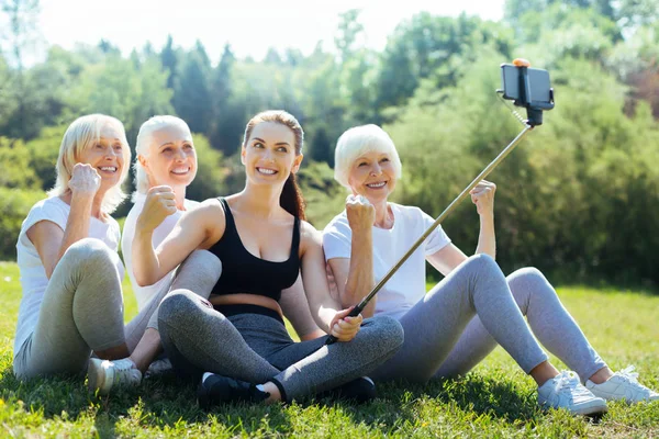 Beautiful brunette holding selfie stick — Stock Photo, Image