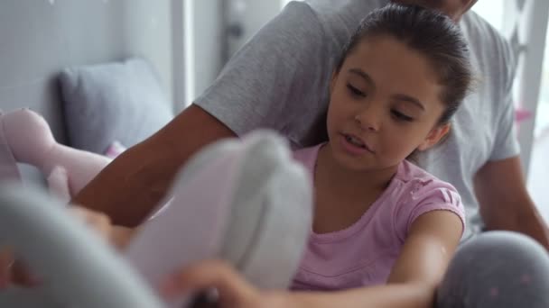 Досить маленька дівчинка відпочиває в спальні з батьком — стокове відео