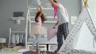 Neşeli küçük kız ve babası yastık ile mücadele