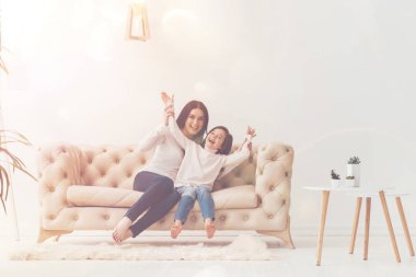 Sevimli çocuk ve annesi kanepede eğleniyor