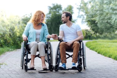 Tekerlekli sandalye açık havada oturup hoş üst düzey Çift