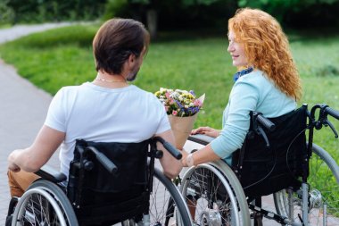 Parkta oturan güzel whelelchaired Çift