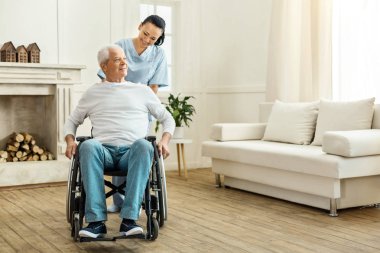 Neşeli pozitif caregiver tekerlekli taşıma