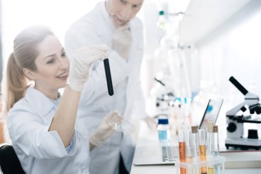 Onun iş arkadaşı siyah sıvı gösteren büyüleyici kadın